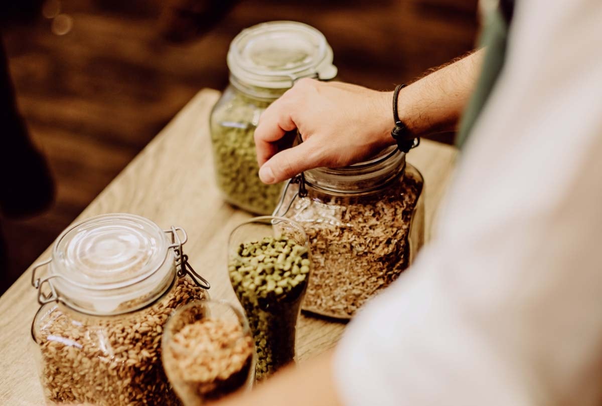 Verschiedene Rohstoffe aufgereiht in Gläsern bei ERDINGER Brauereibesichtigung.