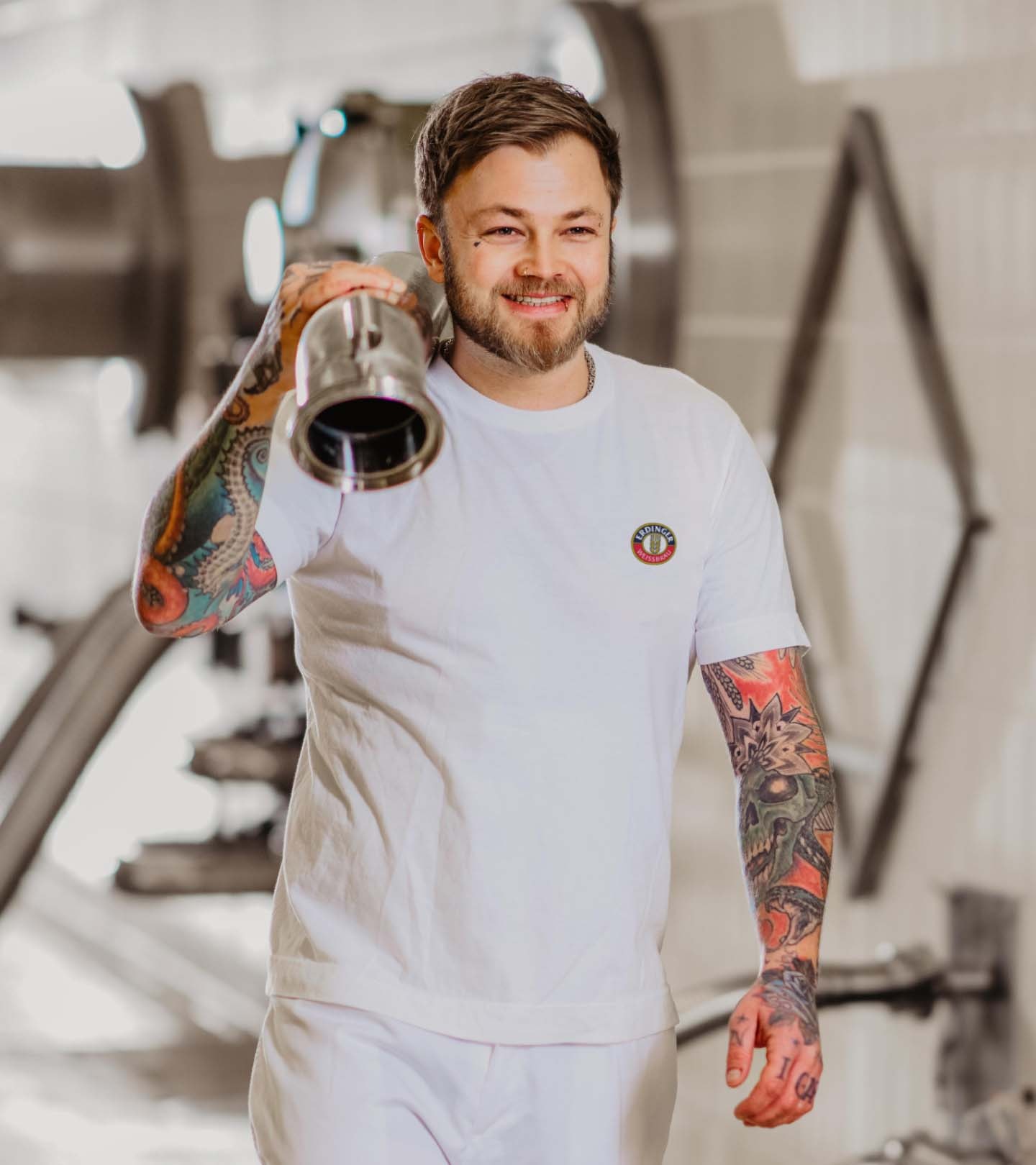 Ein ERDINGER Brauer trägt einen Schlauch.