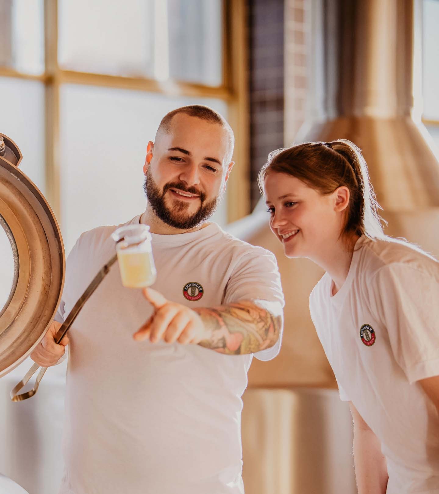 ERDINGER Brauer erklärt Praktikantin eine Bierprobe.