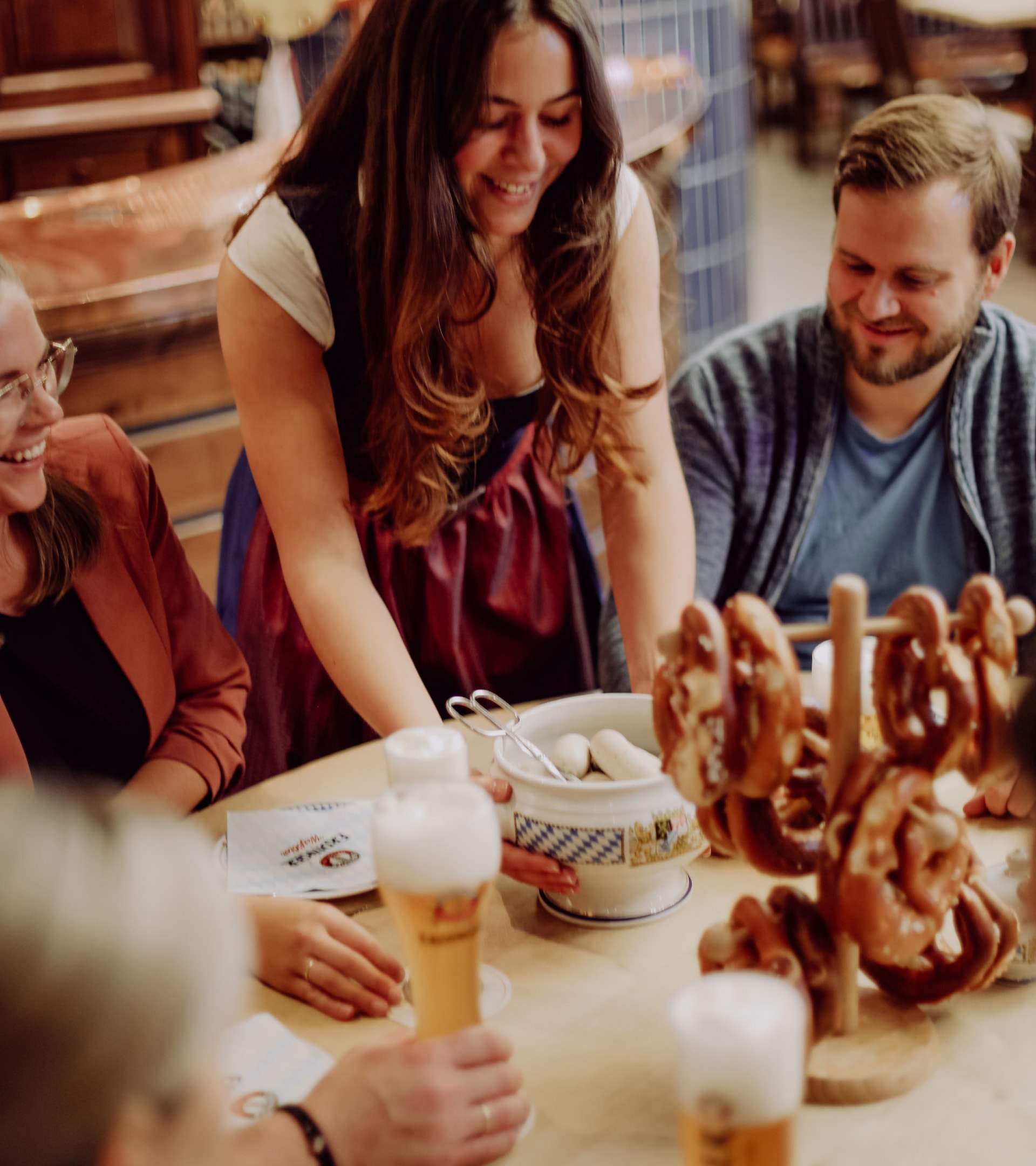 Eine Angestellte bringt einer Gruppe eine bayerische Brotzeit bei der Brauereibesichtigung von ERDINGER.