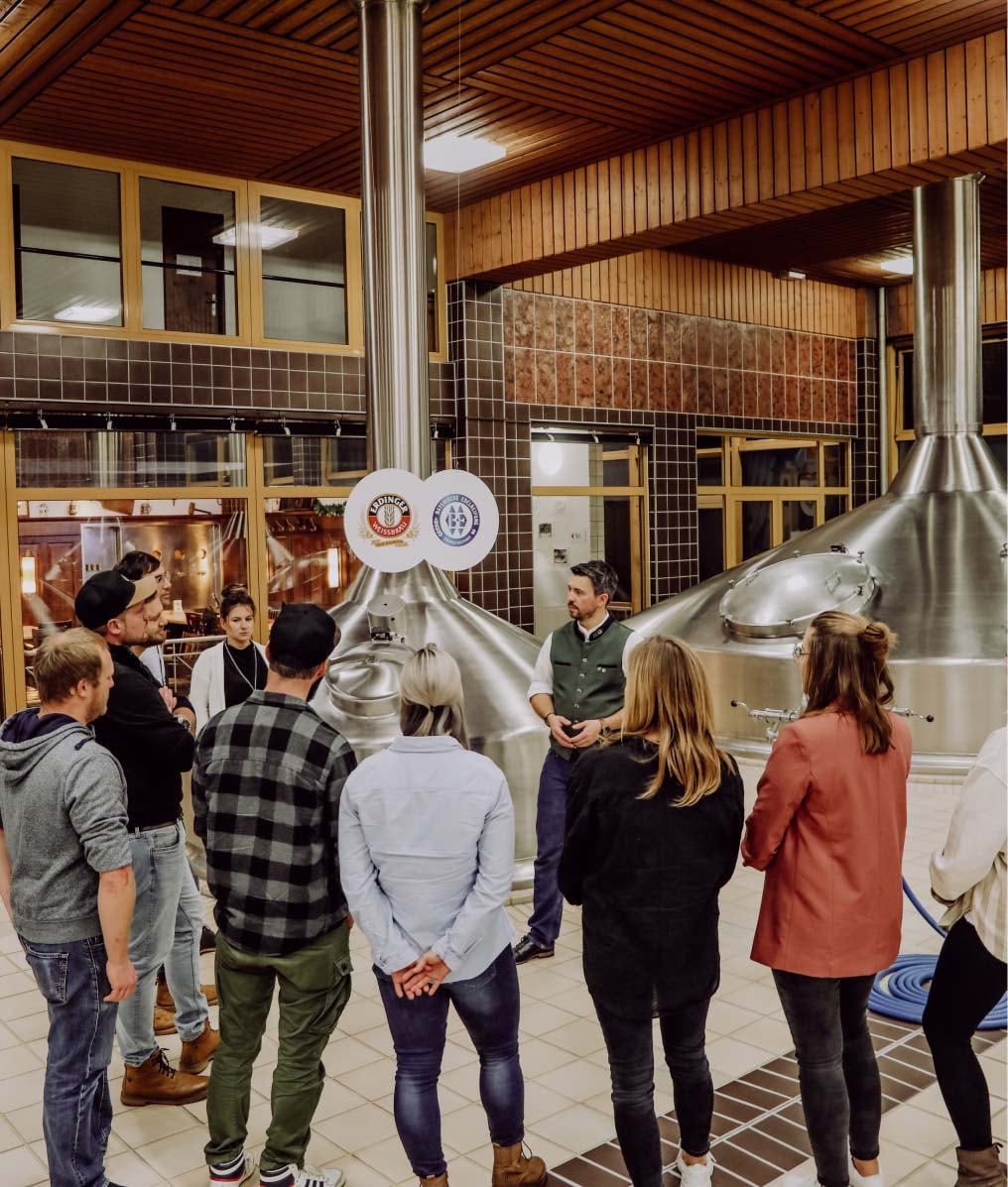 Ein Brauereiführer erklärt einer Gruppe etwas im Sudhaus.