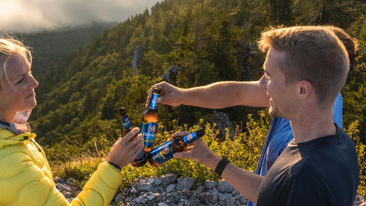 Wanderer genießen den Ausblick am Gipfel und ihr vitaminhaltiges ERDINGER Alkoholfrei.