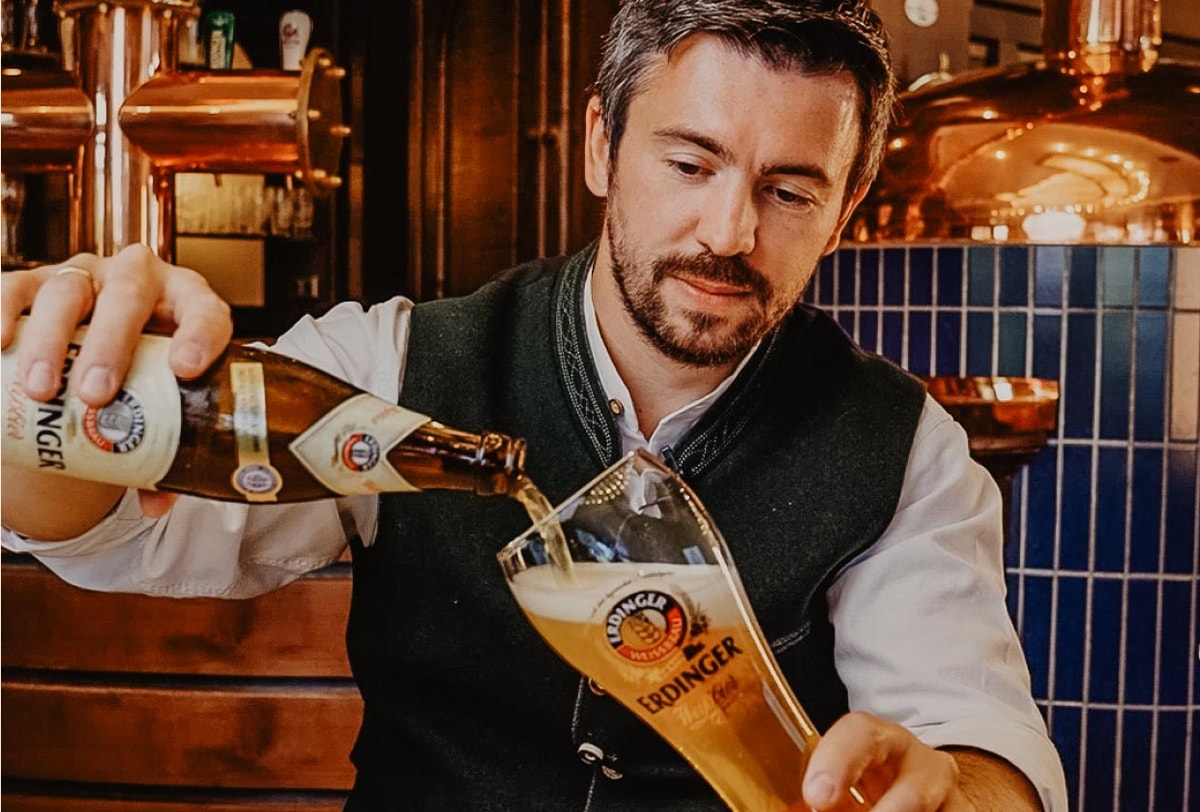 Ein Barkeeper schenkt ERDINGER Weißbier ein.