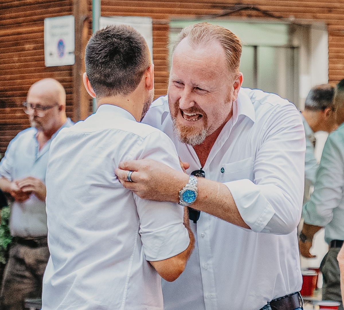 Zwei Kollegen von ERDINGER umarmen sich freundschaftlich.