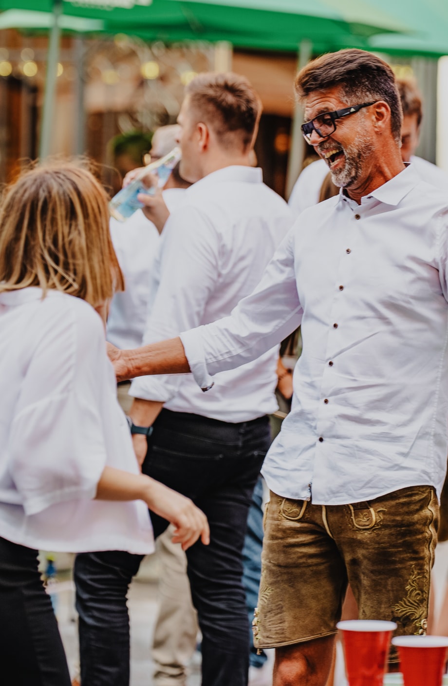 ERDINGER Vertriebsmitarbeiter unterhält sich mit Auszubildenden auf Firmenevent.