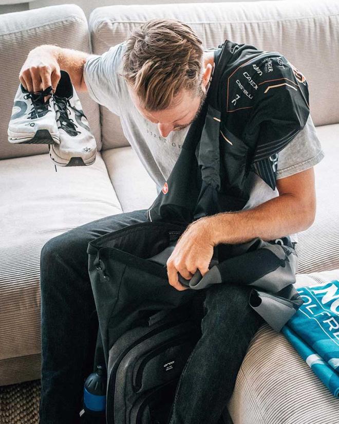 Ein Mann sitzt auf einer Couch und prüft seine Ausrüstung.